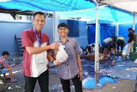 Penyerahan daging oleh panitia kurban PLN Unit Induk Distribusi Sulawesi Selatan, Sulawesi Tenggara, dan Sulawesi Barat, Agus Salim (kiri) kepada penerima manfaat, Amir (kanan) pada Jumat (6/6). Amir menyampaikan rasa syukurnya atas bantuan yang sangat berarti bagi keluarganya di momen Iduladha ini.