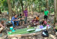 Momen kebersamaan makan bersama antara TNI dan Warga saat istirahat pekerjaan pembangunan jembatan gantung garuda. Foto: dok Pendim 