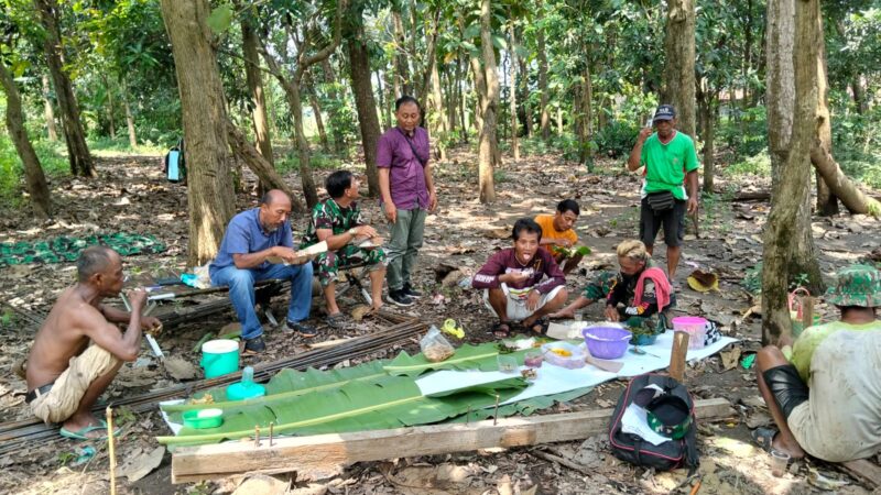 Momen kebersamaan makan bersama antara TNI dan Warga saat istirahat pekerjaan pembangunan jembatan gantung garuda. Foto: dok Pendim 